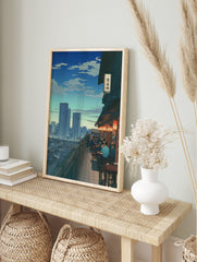 Illustrative print of a Japanese rooftop restaurant with diners and orange lanterns, in an alternate framed mockup