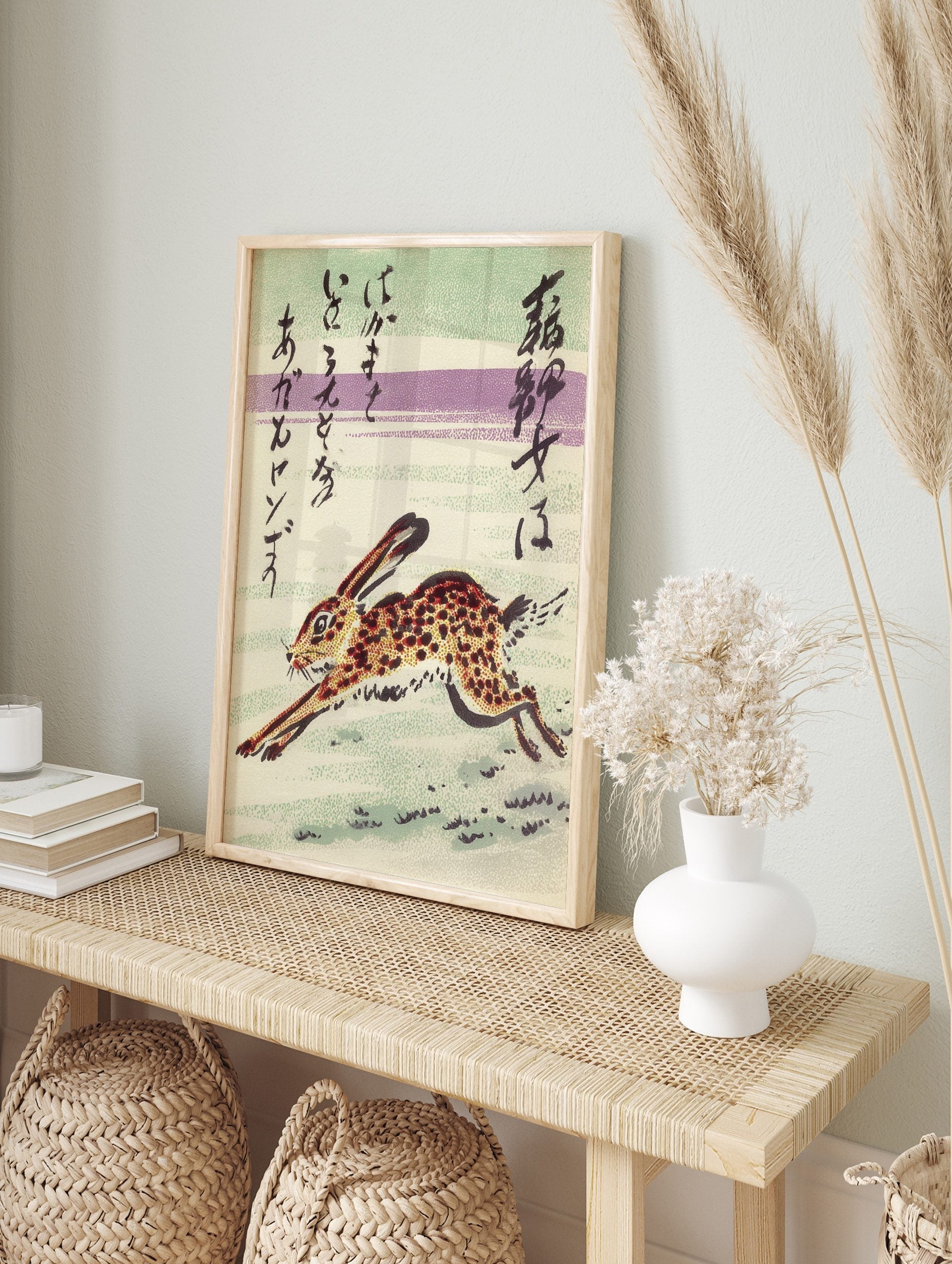 Japanese art print of a spotted running rabbit with calligraphic text on a striped green and, in an alternate framed mockup