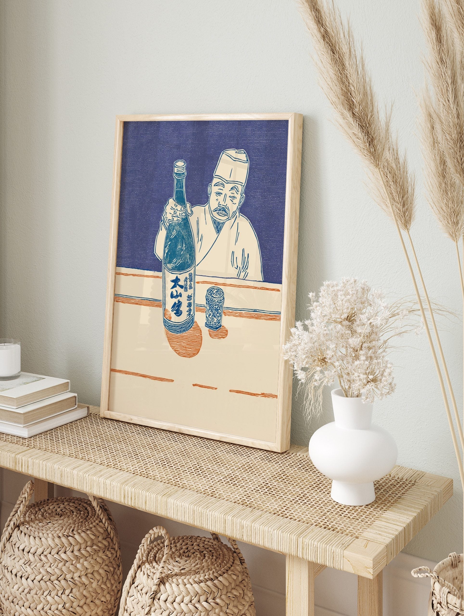 Japanese man in traditional attire holding a sake bottle and presenting it, with a patterned, in an alternate framed mockup
