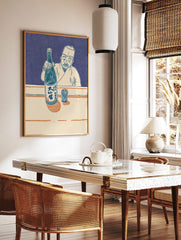 Japanese man in traditional attire holding a sake bottle and presenting it, with a patterned cup on, in a styled room mockup