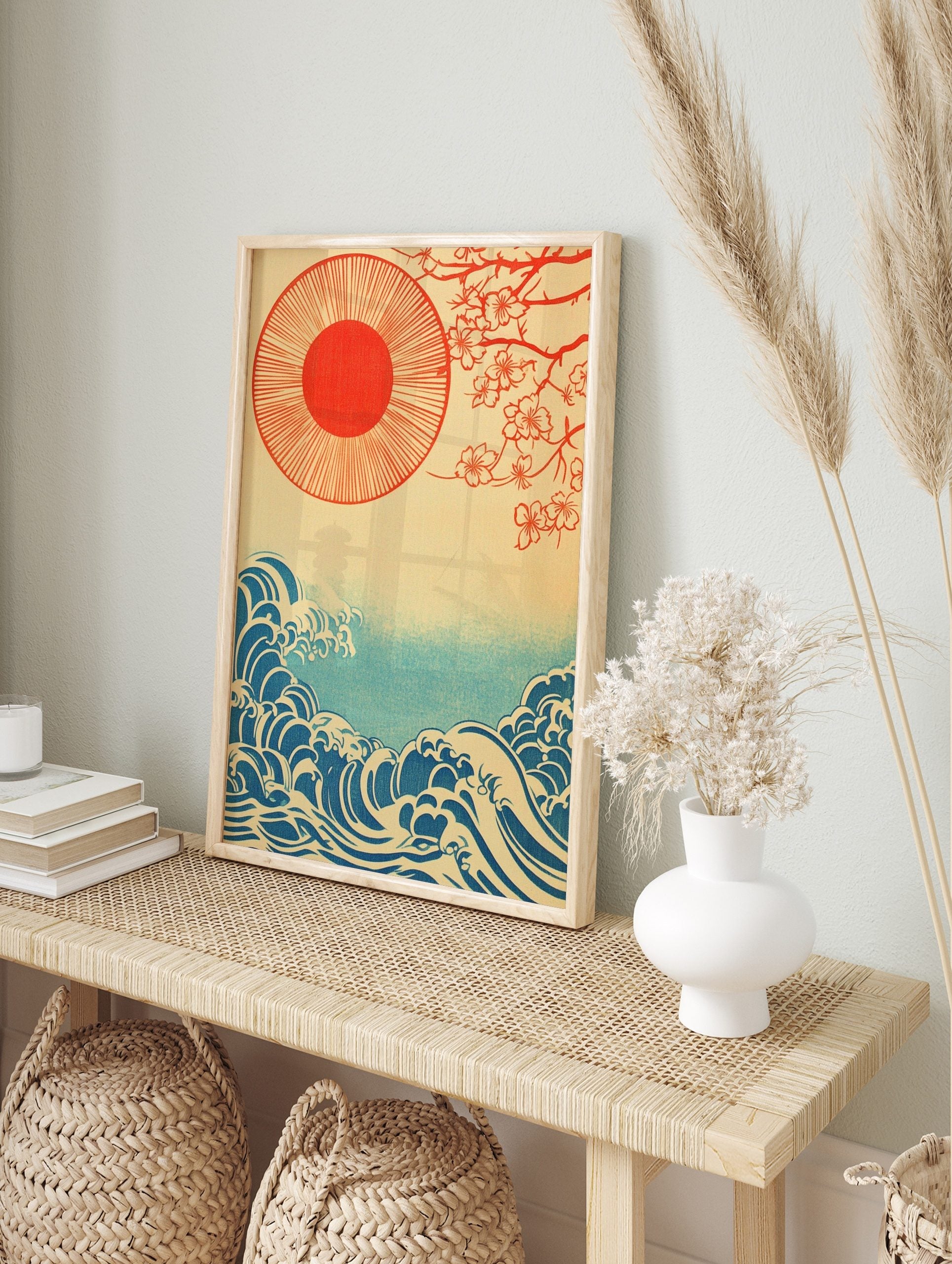 Japanese illustration with red sun, cherry blossom branches, and blue ocean waves on a beige, in an alternate framed mockup