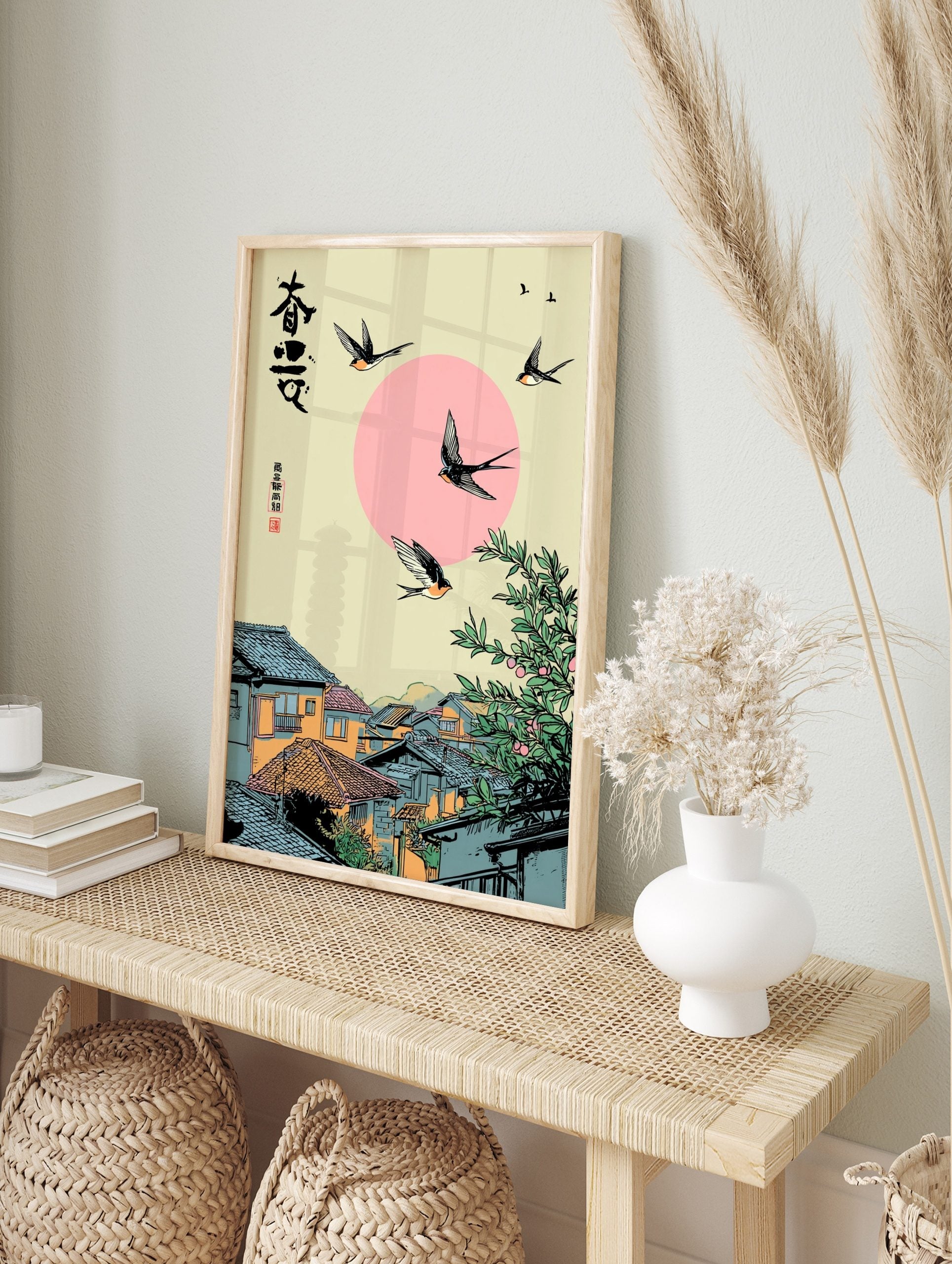 Japanese swallows flying over a traditional village with a pink sun and green tree, featuring, in an alternate framed mockup