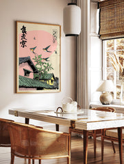 Ukiyo-e style Japanese swallows flying over traditional rooftops with green tiles and a leafy branch, in a styled room mockup