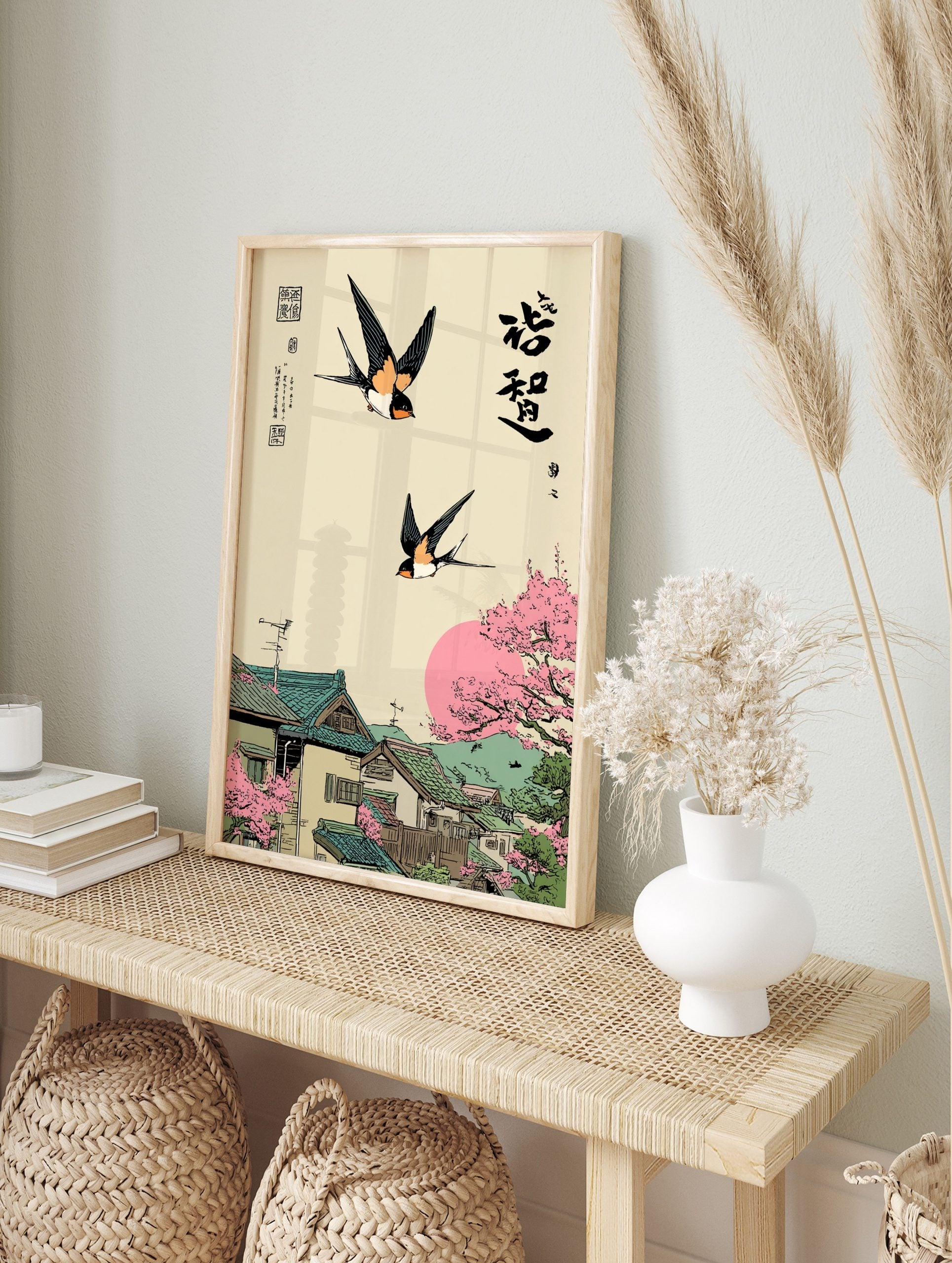 Japanese Ukiyo-e style art print with two swallows flying over a village with cherry blossoms, in an alternate framed mockup