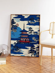 Japanese Wall Art print of a blue pagoda, traditional houses, and trees in a serene mountain landscape. - Image 2