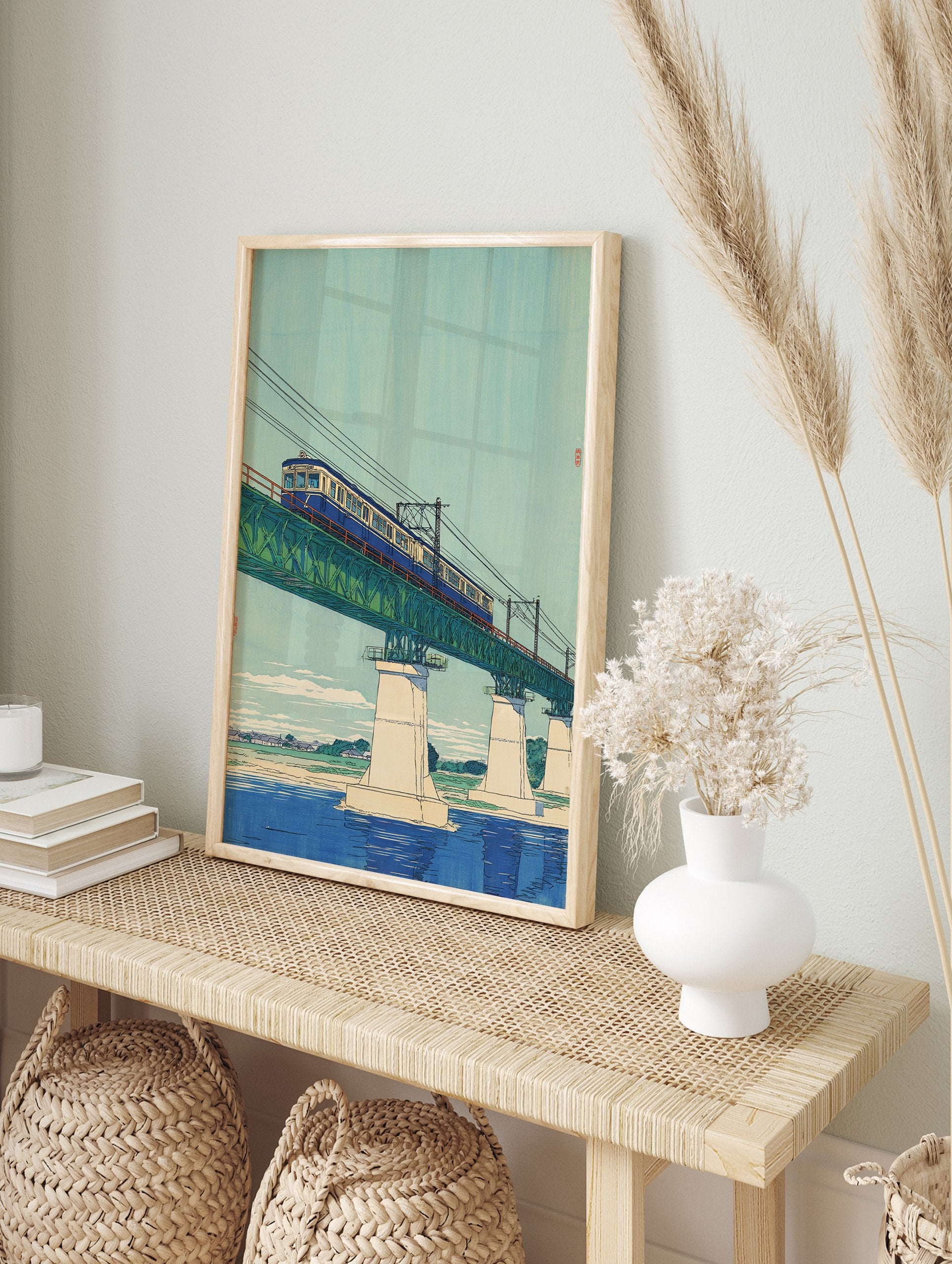 Japanese wall art print of a blue train on a green truss bridge over a river, with a light blue sky and distant landscape. - Image 3