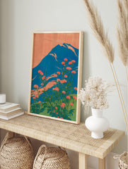 Japanese wall art print of Mount Fuji with red-orange flowers and a blue mountain against an orange sky. - Image 3