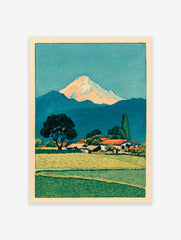 Japanese woodblock print of Mount Fuji over a village with green fields and a large tree in the foreground.