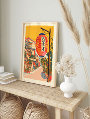 Illustrative Japanese street scene wall art with a large red lantern, traditional buildings, and green foliage under an orange sky. - Image 3