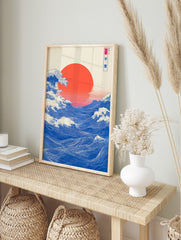 Japanese Ukiyo-e style ocean wave art print with large red sun and blue water, in an alternate framed mockup