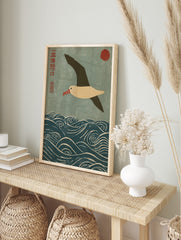 Japanese woodblock print of an albatross flying over blue waves with a red sun and kanji, in an alternate framed mockup