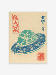 Traditional Japanese Woodblock Print depicting a blue and teal patterned hat with cultural characters on a beige background.