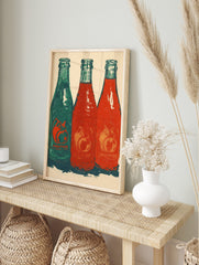 Three Jarritos soda bottles, one green and two red, with fruit motifs and 'JARIITOS' text, in, in an alternate framed mockup