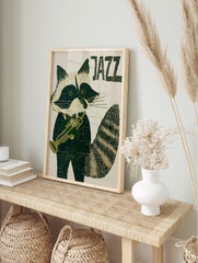 Stylised raccoon in a tuxedo playing a trumpet with JAZZ text in deep green and cream, in an alternate framed mockup