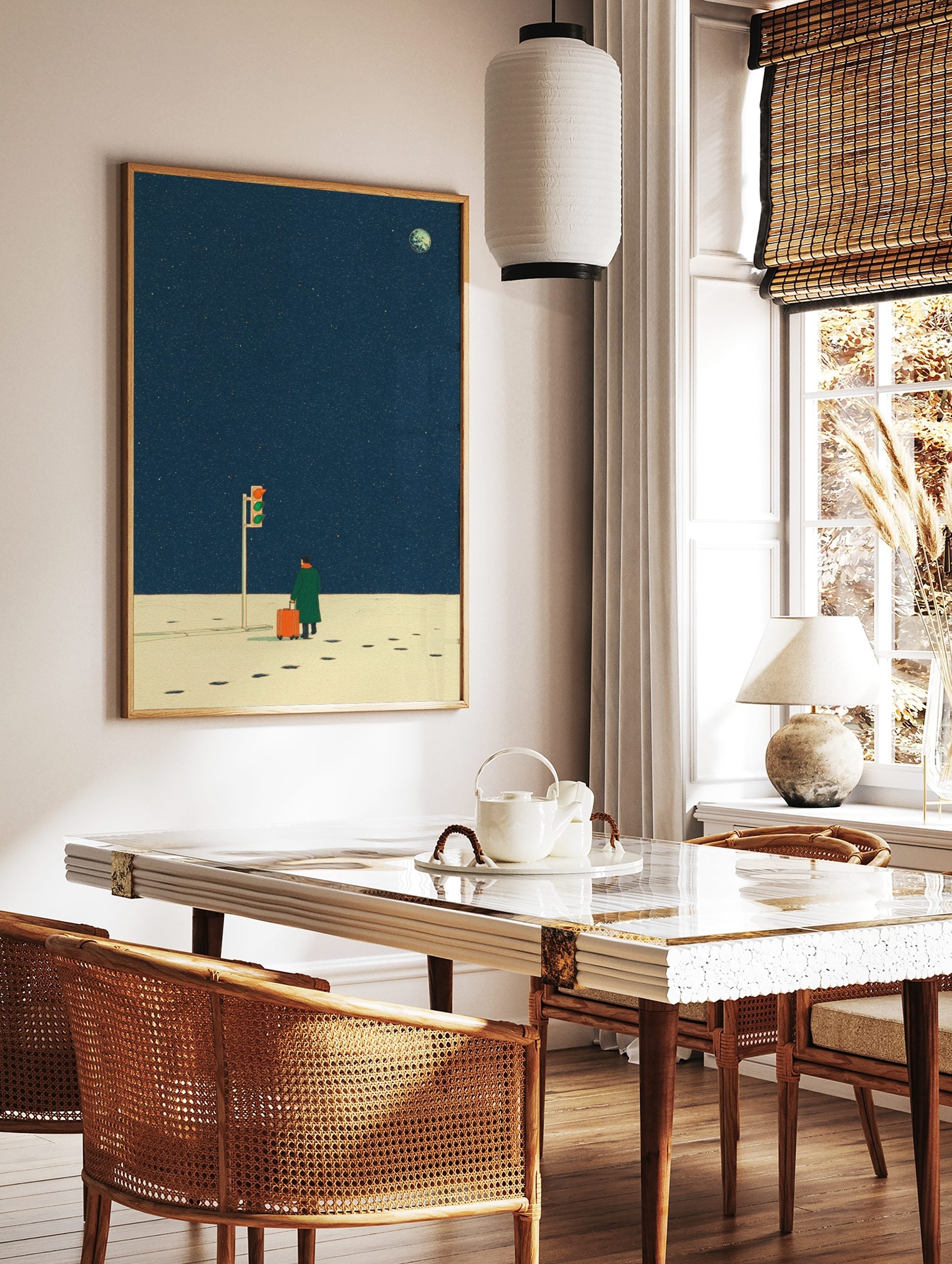 Illustrative print of a person with orange suitcase at traffic light under a deep blue starry night, in a styled room mockup