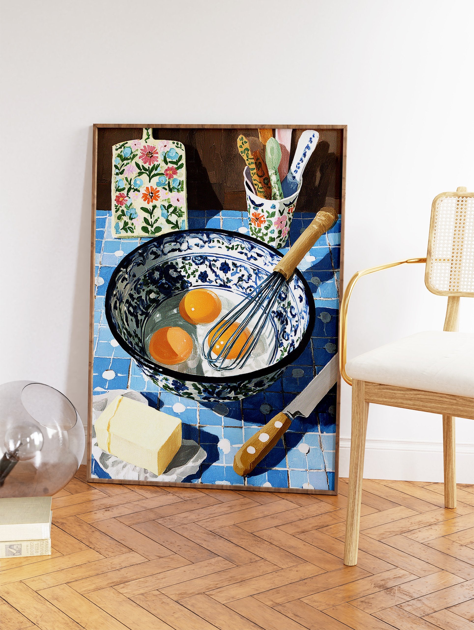 Illustrative kitchen baking scene with eggs, whisk, butter, and floral cutting board on blue tiles, kitchen wall art. - Image 2