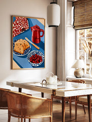 Still life wall art print featuring a red moka pot, fruit bread slices, and a bowl of cherries on a, in a styled room mockup