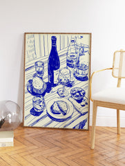 Blue line art kitchen wall art print of a dining scene with wine bottles, glasses, bread, and olives on a striped table. - Image 2