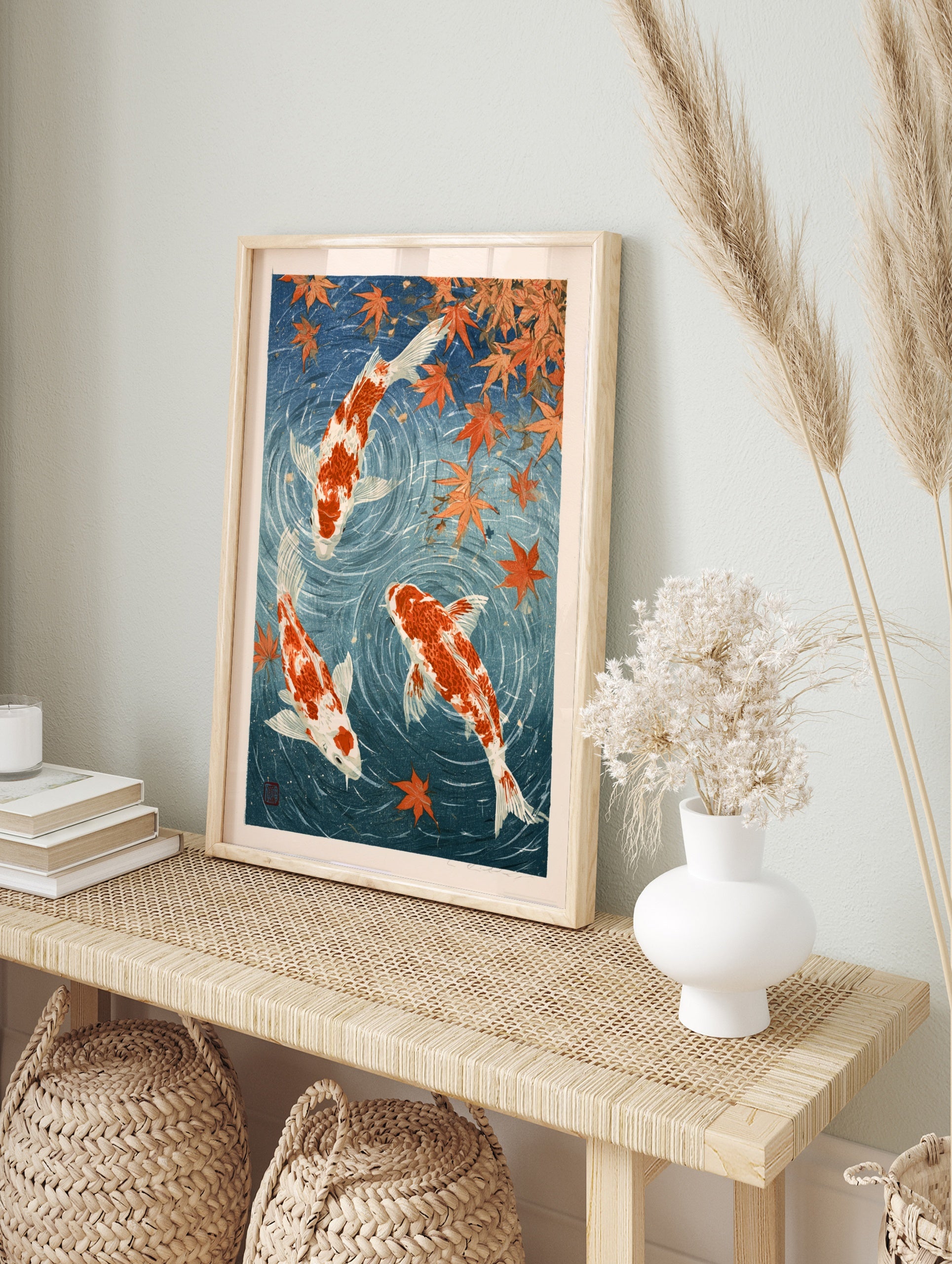 Japanese-style koi fish wall art print with orange carp and maple leaves in deep blue water, in an alternate framed mockup