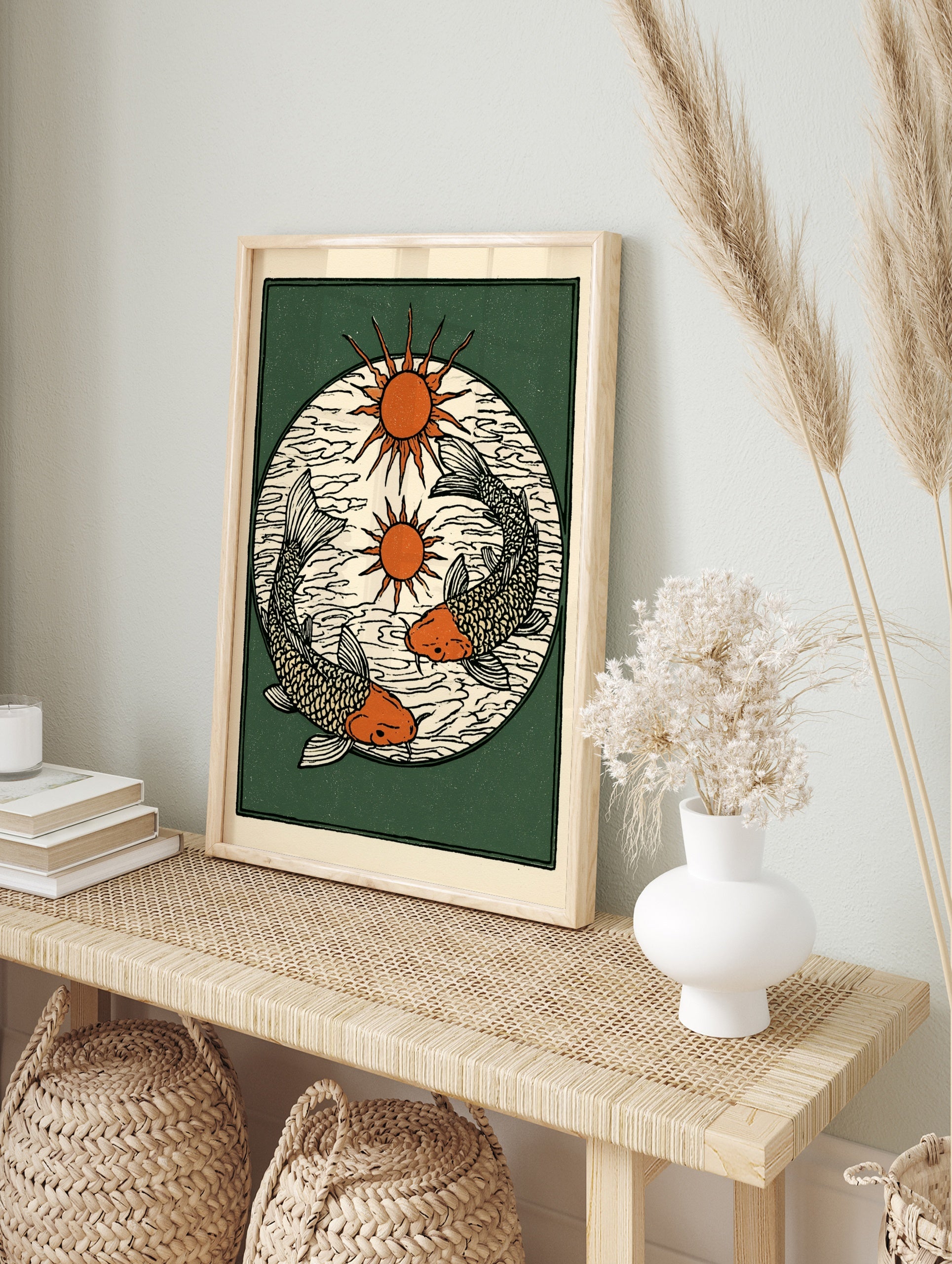 Illustrative koi fish wall art with two sun icons on a dark green background, block-print, in an alternate framed mockup