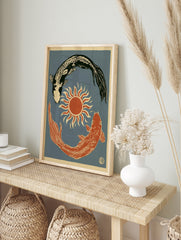 Illustrative koi fish wall art print with a sun symbol on a blue background, in an alternate framed mockup
