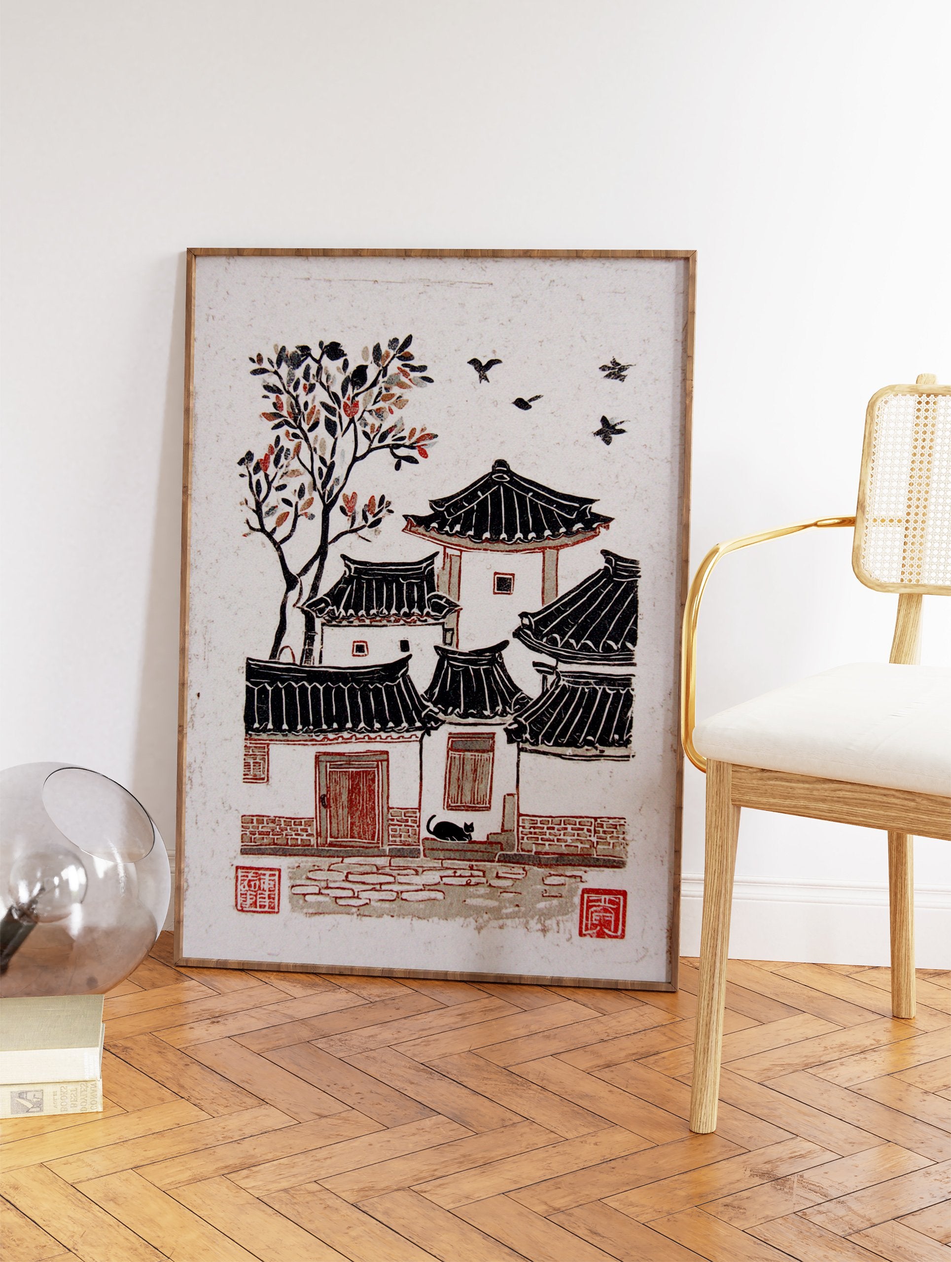 Woodcut print of a traditional Korean village with Hanok houses, a tree with red leaves, black cat, and flying birds. - Image 2
