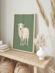 Minimalist illustration of a white lamb on a muted green background, art print, in an alternate framed mockup