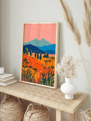 Vibrant illustrative landscape wall art with an orange wildflower field, blue mountains, pink sky, and green trees. - Image 3