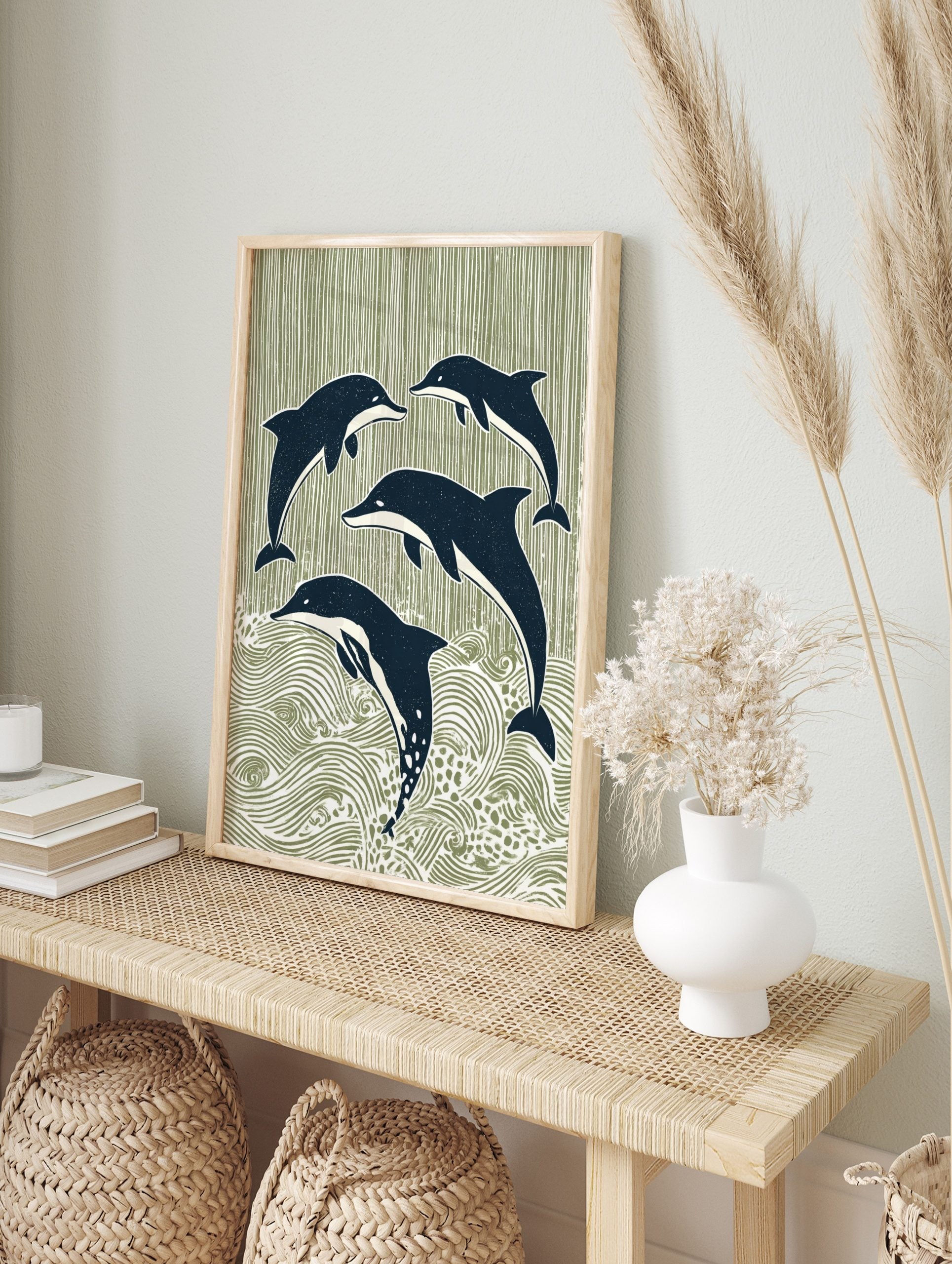 Four stylised navy blue dolphins leaping and swimming against a sage green striped and wavy, in an alternate framed mockup