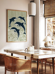 Four stylised navy blue dolphins leaping and swimming against a sage green striped and wavy, in a styled room mockup