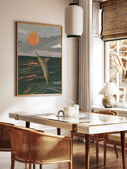 Illustrative print of a marlin leaping from dark ocean water towards a large orange sun in a grey, in a styled room mockup