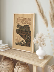 Illustrative leopard resting on a cliff with a mountain and sun in earthy brown and beige, in an alternate framed mockup