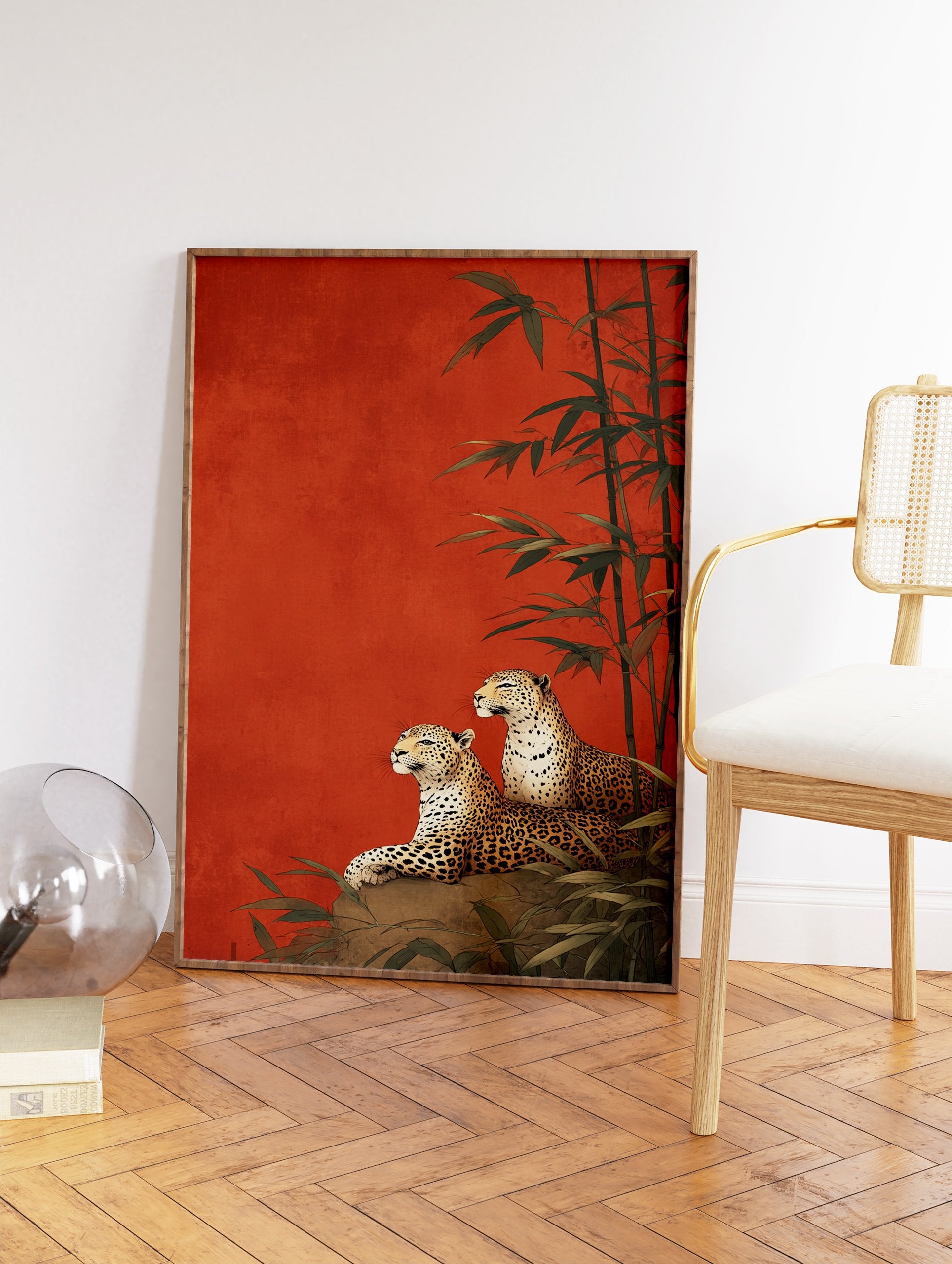 Two leopards lounging on a rock with bamboo stalks against a rich red-orange background in an illustrative leopard wall art print. - Image 2