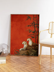 Two leopards lounging on a rock with bamboo stalks against a rich red-orange background in an illustrative leopard wall art print. - Image 2