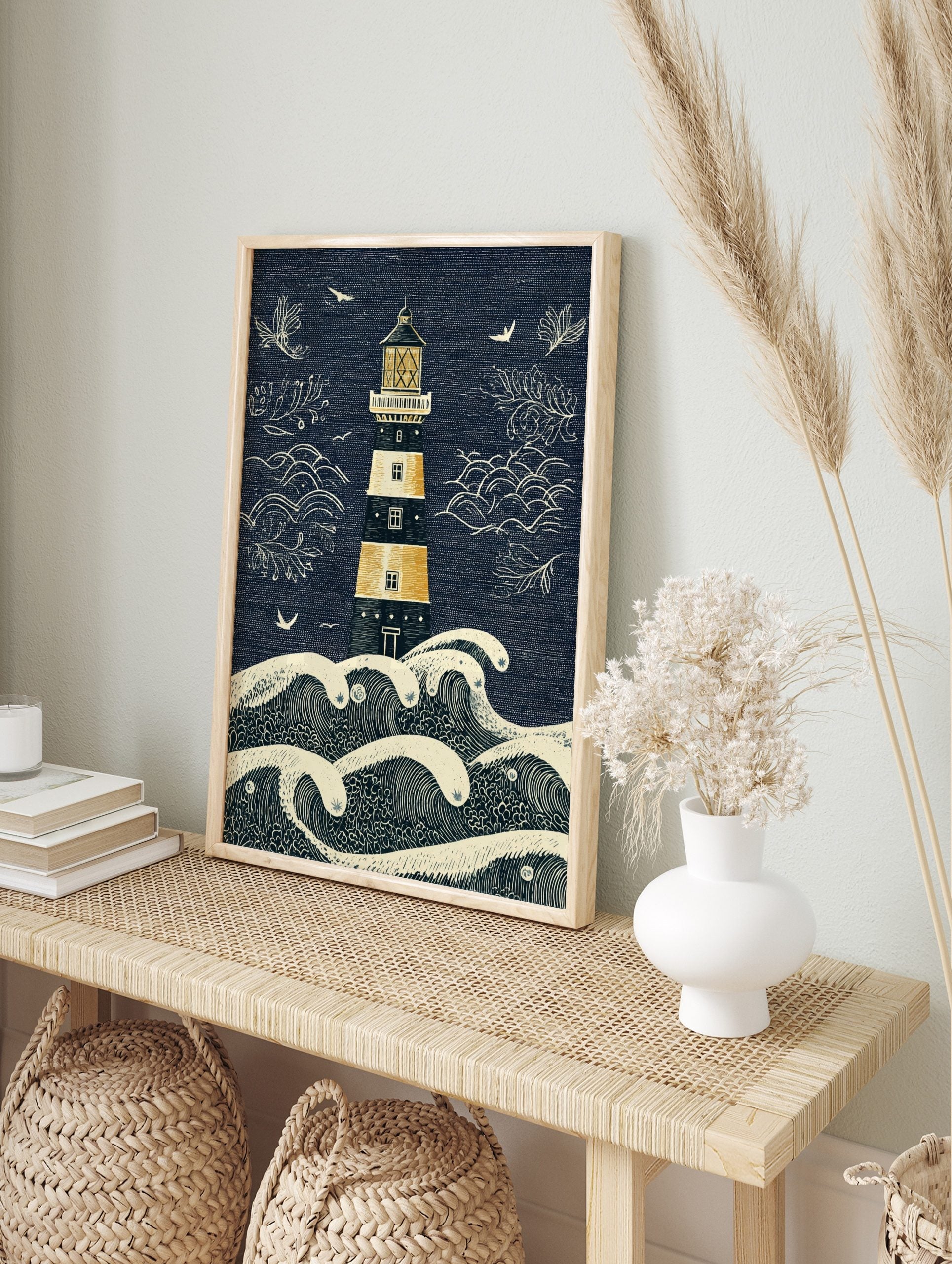 Illustrative lighthouse and crashing waves art print in navy blue, golden yellow, and beige, in an alternate framed mockup