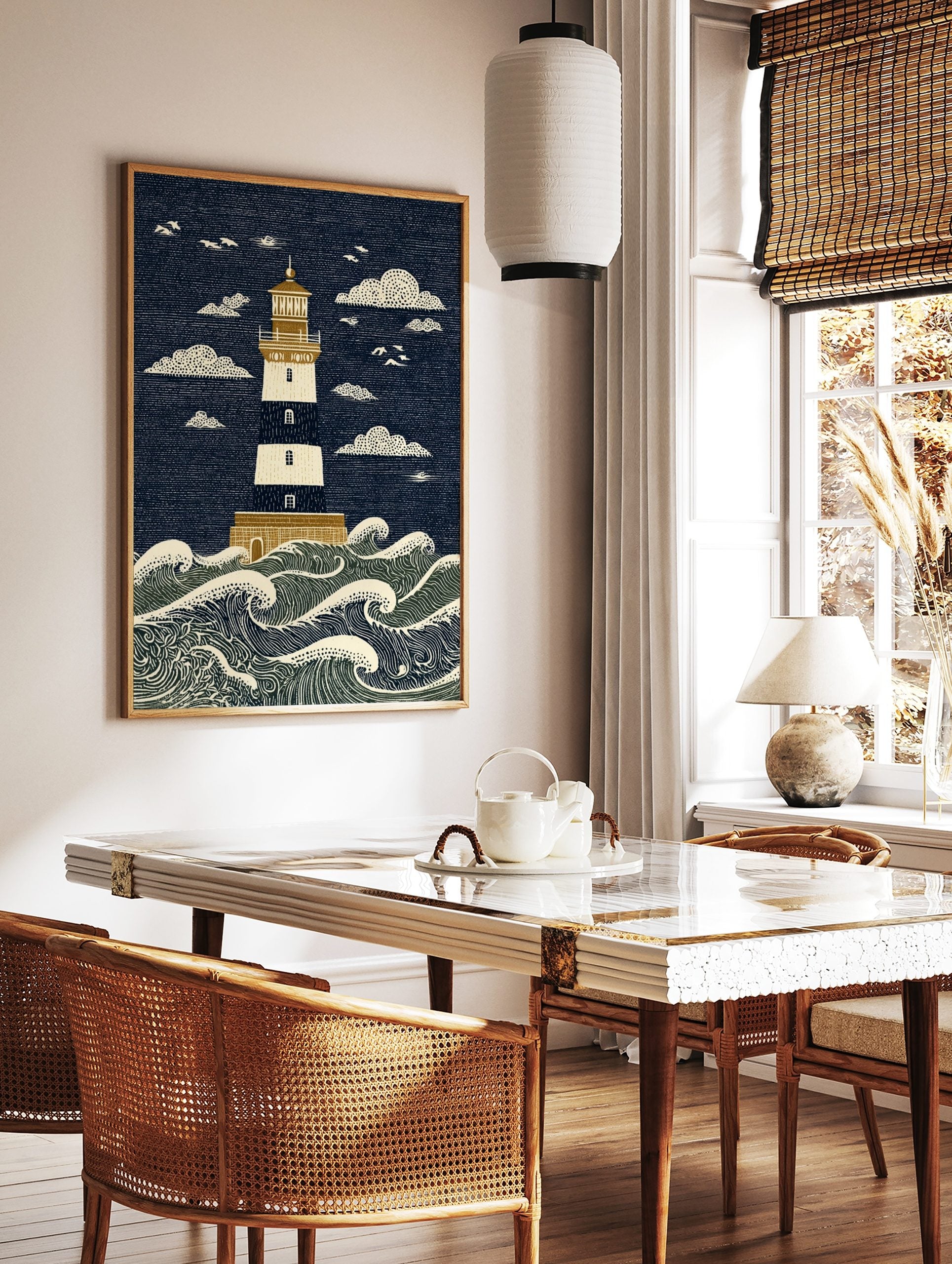 Illustrative lighthouse art print with navy and cream stripes, golden details, and crashing ocean, in a styled room mockup