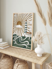 Illustrative lighthouse wall art with green and white stripes, golden sunburst, white clouds, in an alternate framed mockup