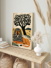Illustrative lion with black and white patterned mane resting under a tree on a yellow, in an alternate framed mockup