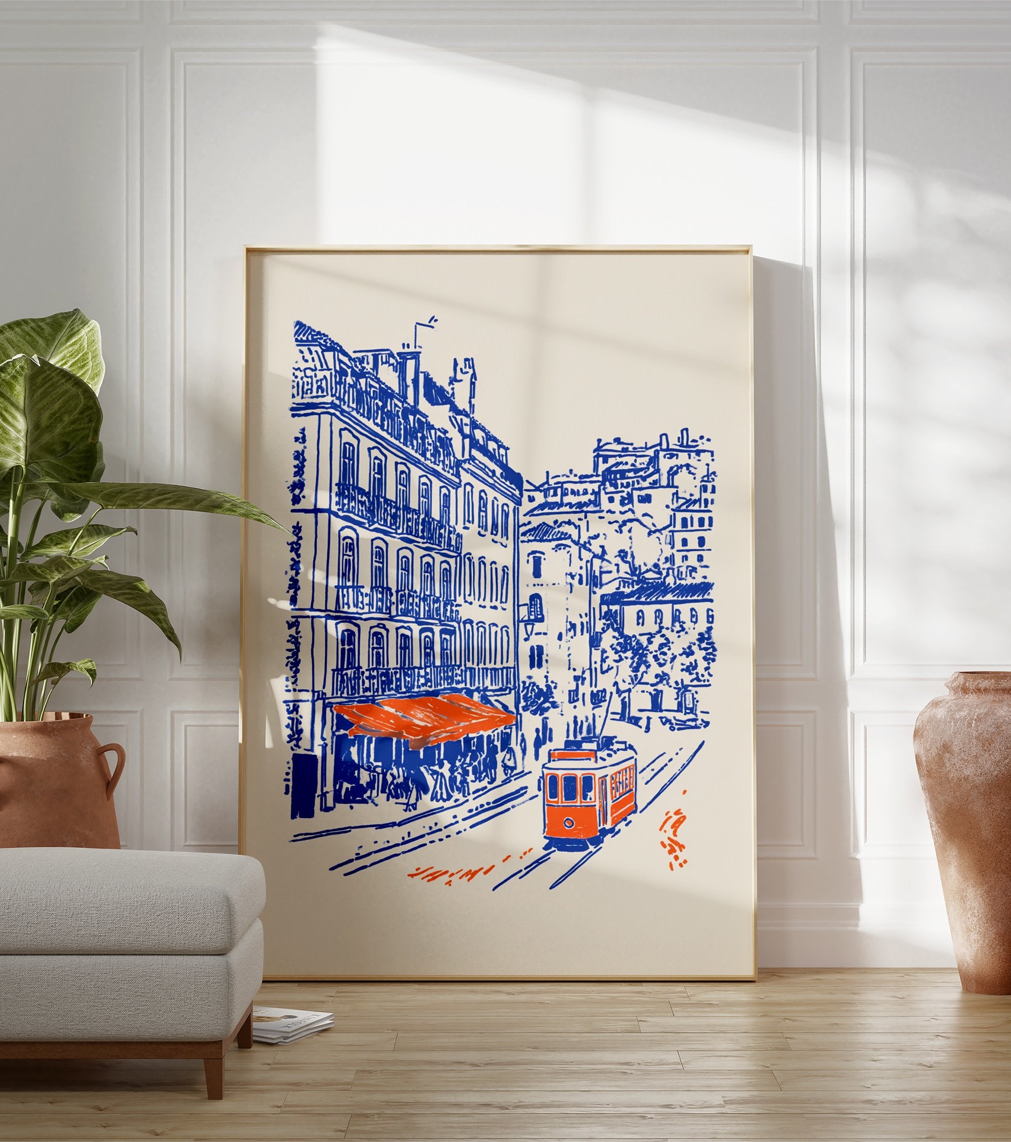 Lisbon Street Poster showing a blue and orange illustration of a city street with an orange tram, buildings, and a cafe. - Image 3