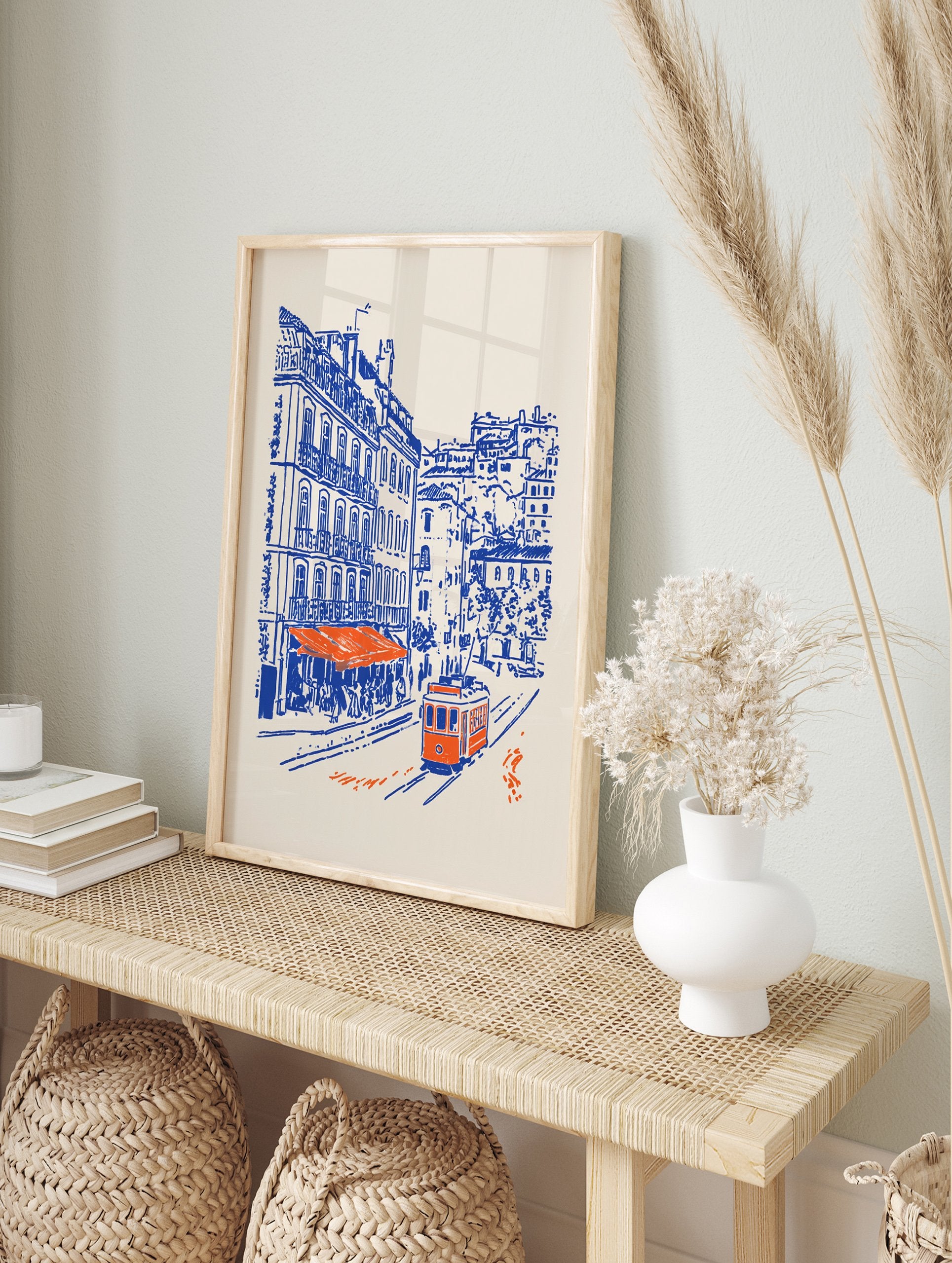 Lisbon Street Poster showing a blue and orange illustration of a city street with an orange tram, buildings, and a cafe. - Image 4