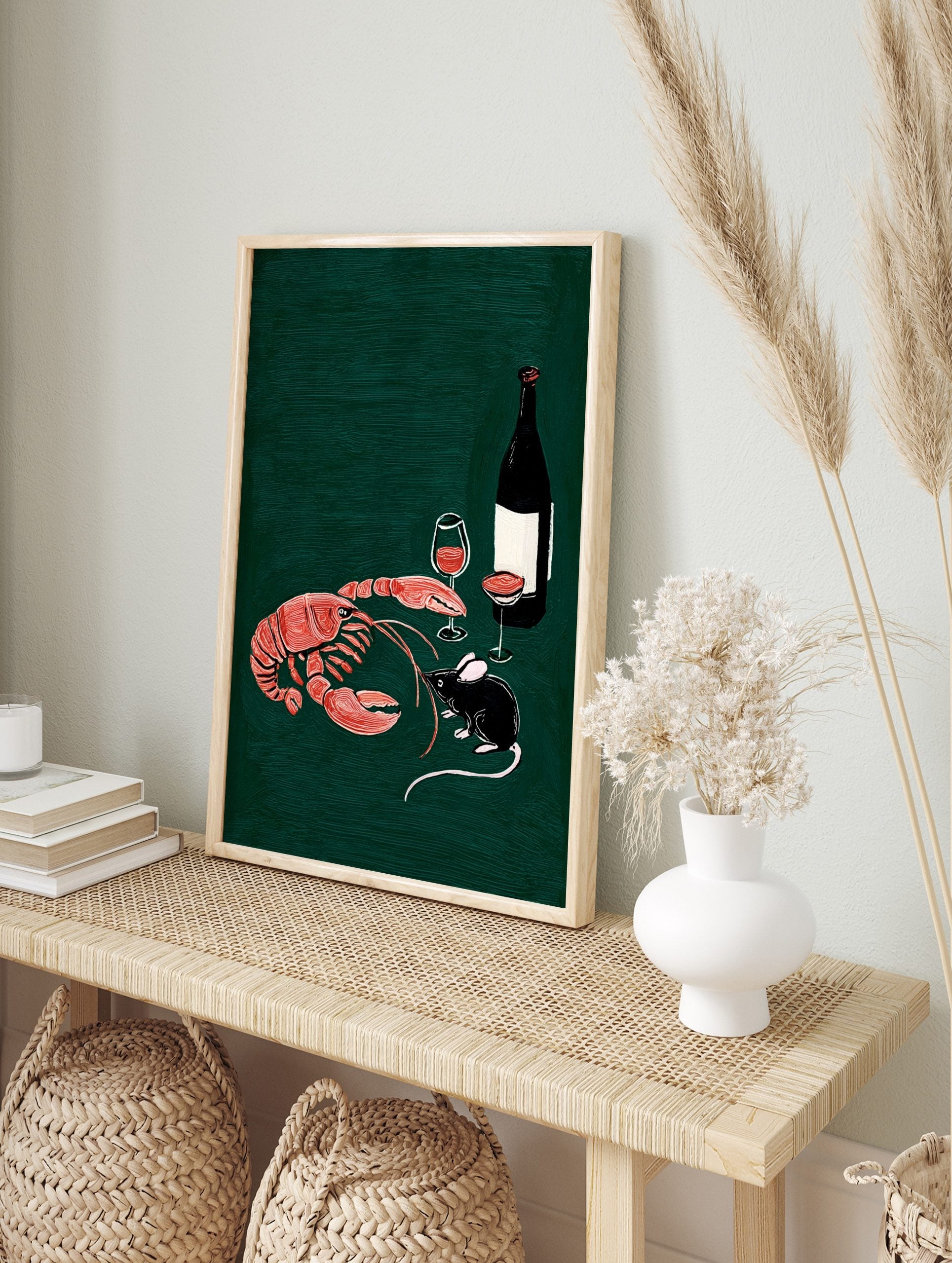 Illustrative print of a red-orange lobster, black mouse, wine bottle, and glasses on a dark, in an alternate framed mockup