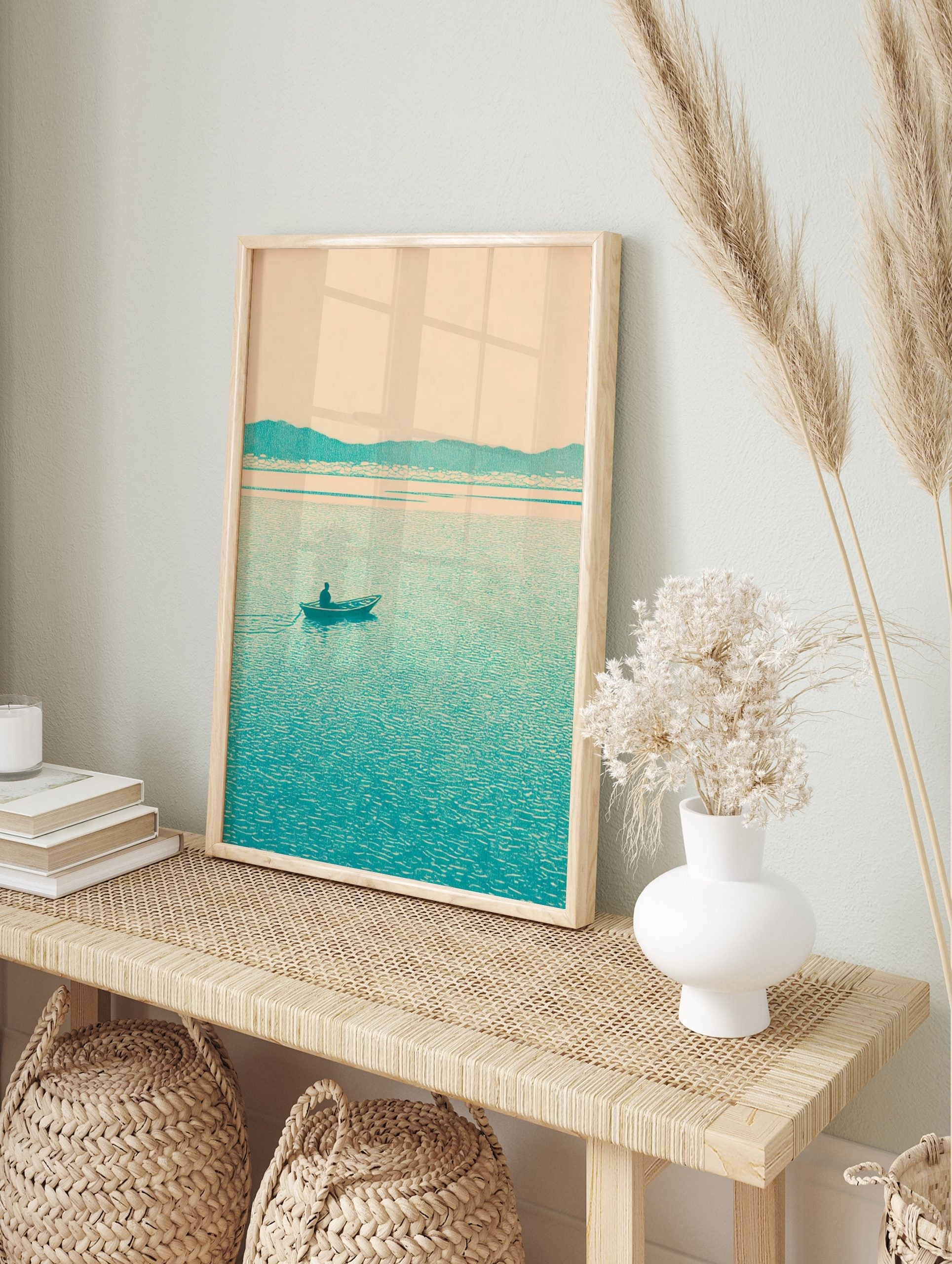 Minimalist teal landscape print with a lone boatman on a lake and distant mountains under a, in an alternate framed mockup