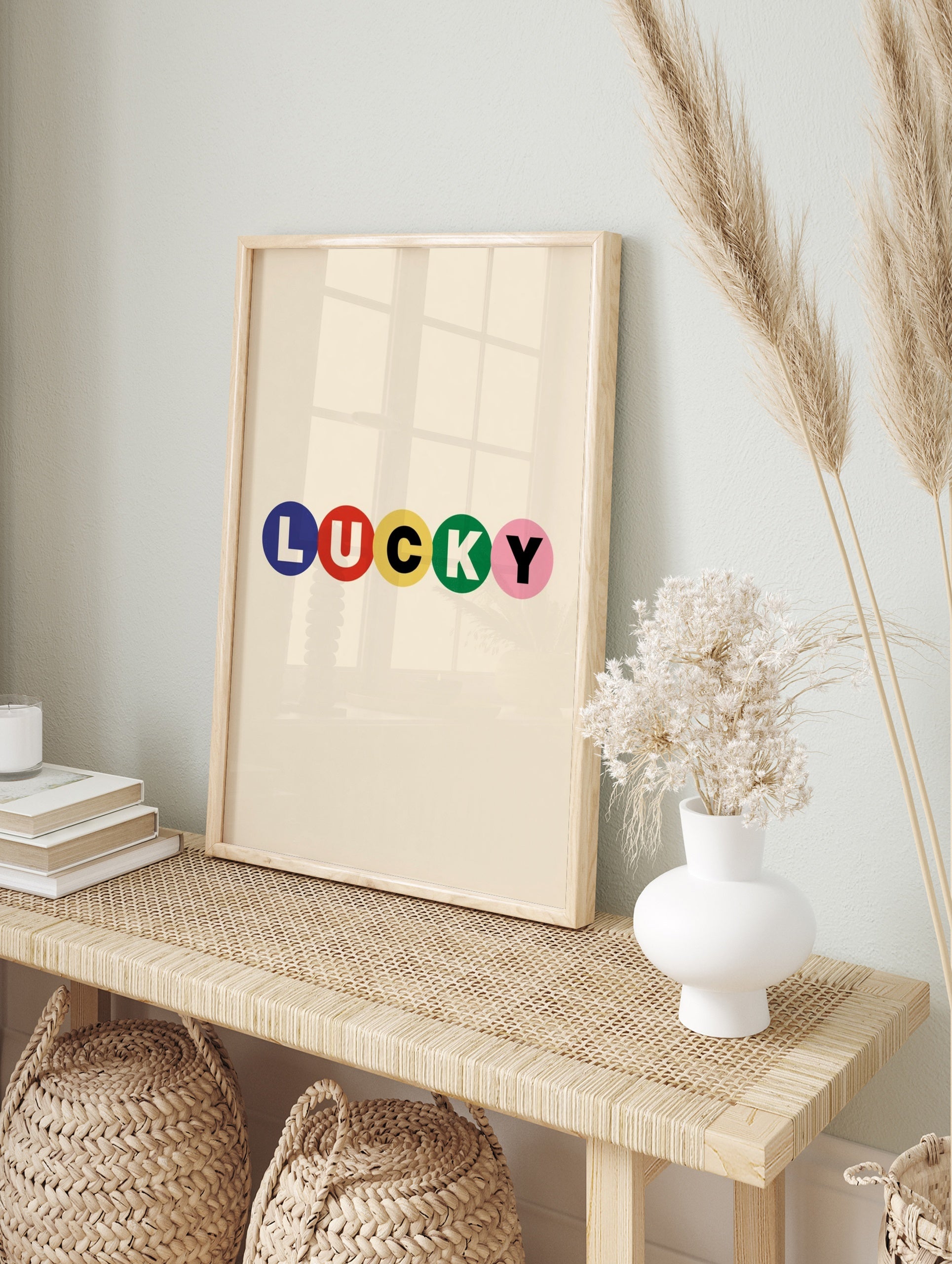 Typography wall art with the word LUCKY in blue, red, yellow, green, and pink circles on a, in an alternate framed mockup