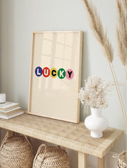 Typography wall art with the word LUCKY in blue, red, yellow, green, and pink circles on a, in an alternate framed mockup