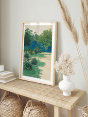 Lush tropical garden print with green foliage, agave plants, and a deep blue background, in an alternate framed mockup