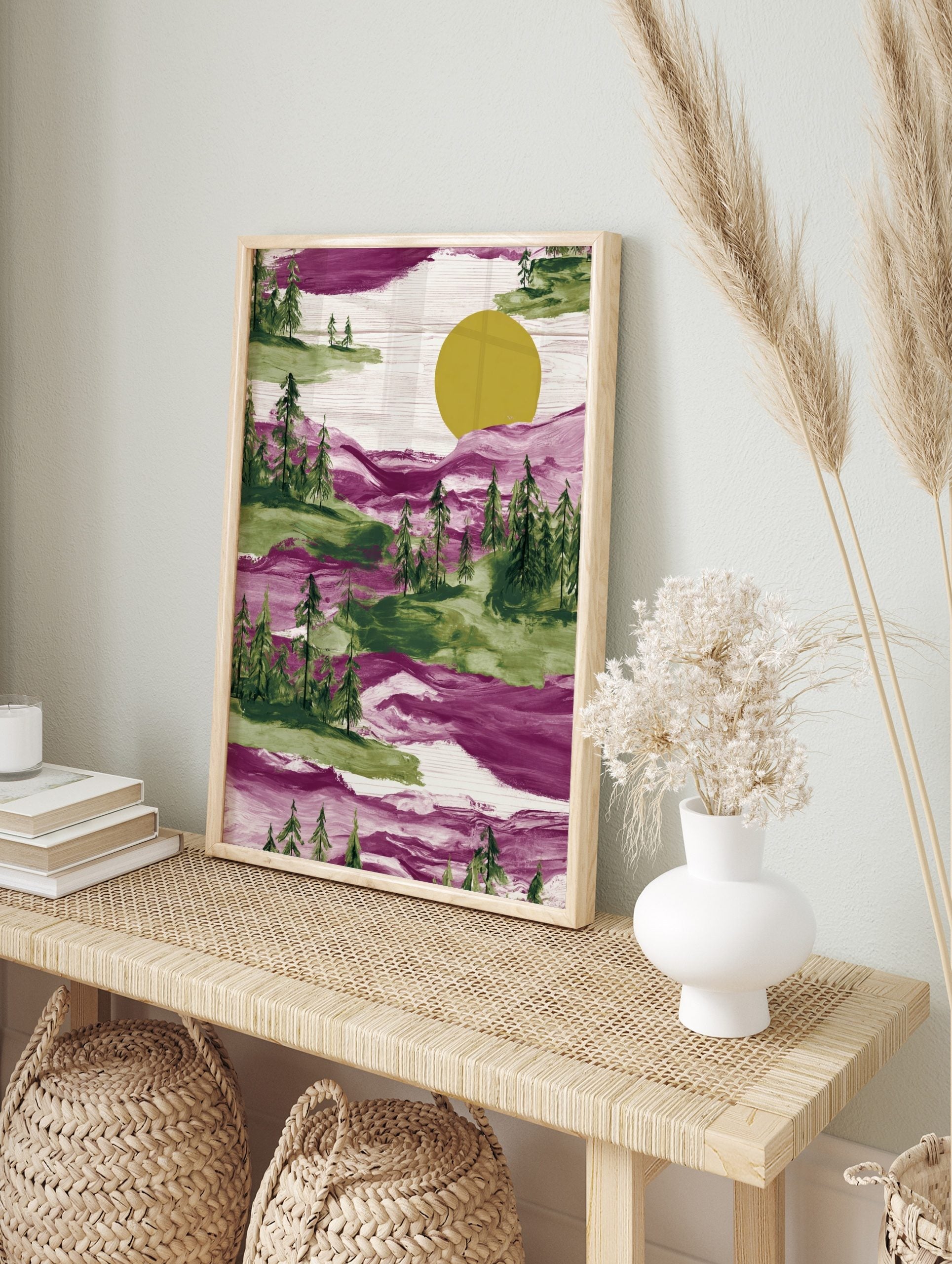 Illustrative magenta and green forest landscape with pine trees and a large yellow sun, with, in an alternate framed mockup