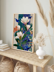 Illustrative botanical art print with pink magnolias, green leaves, and flying blue birds on, in an alternate framed mockup