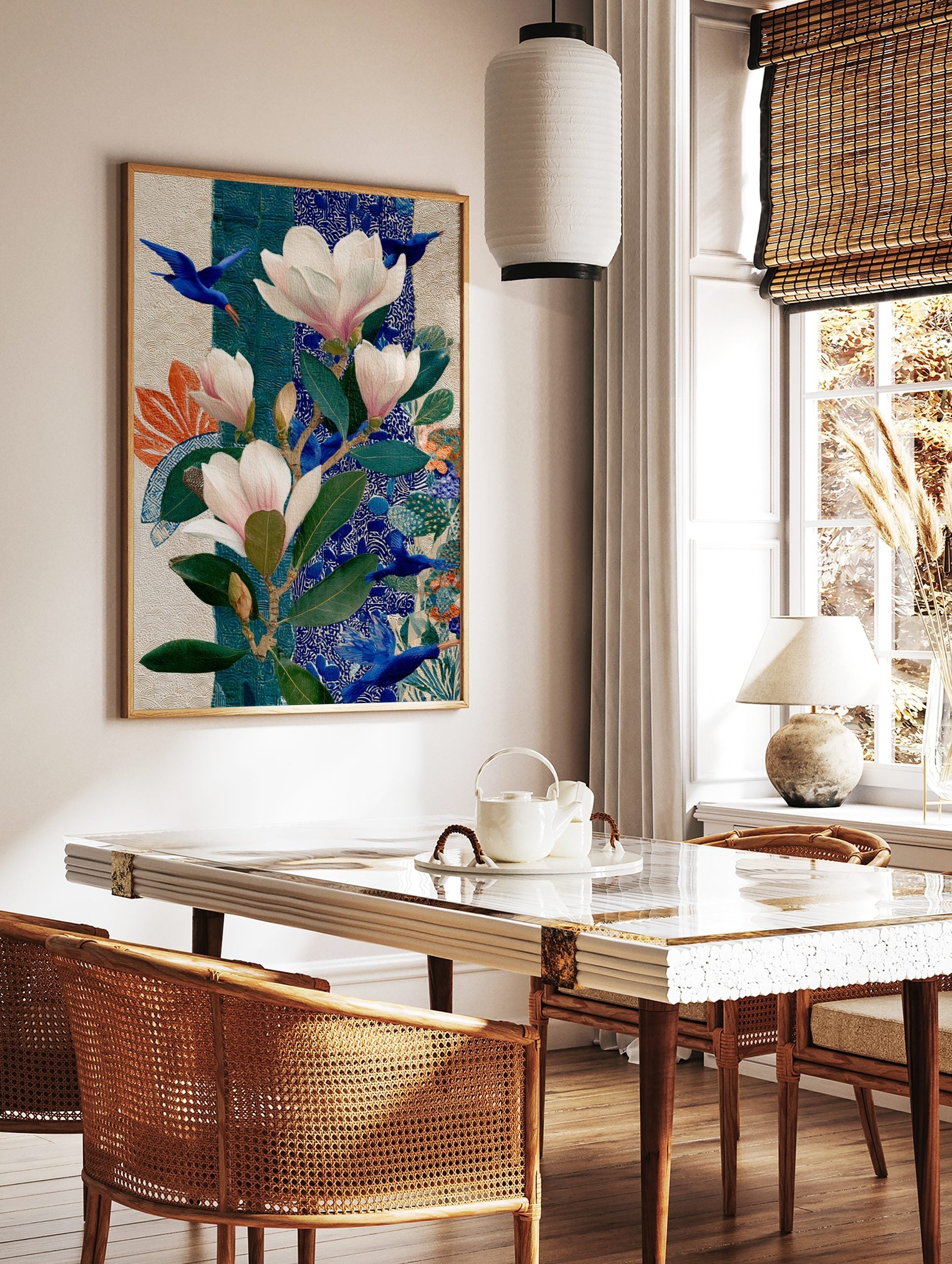 Illustrative botanical art print with pink magnolias, green leaves, and flying blue birds on a, in a styled room mockup