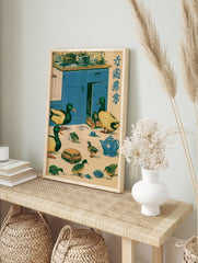 Vintage style illustration of mallard ducks in a blue kitchen with tea set and Japanese text, in an alternate framed mockup