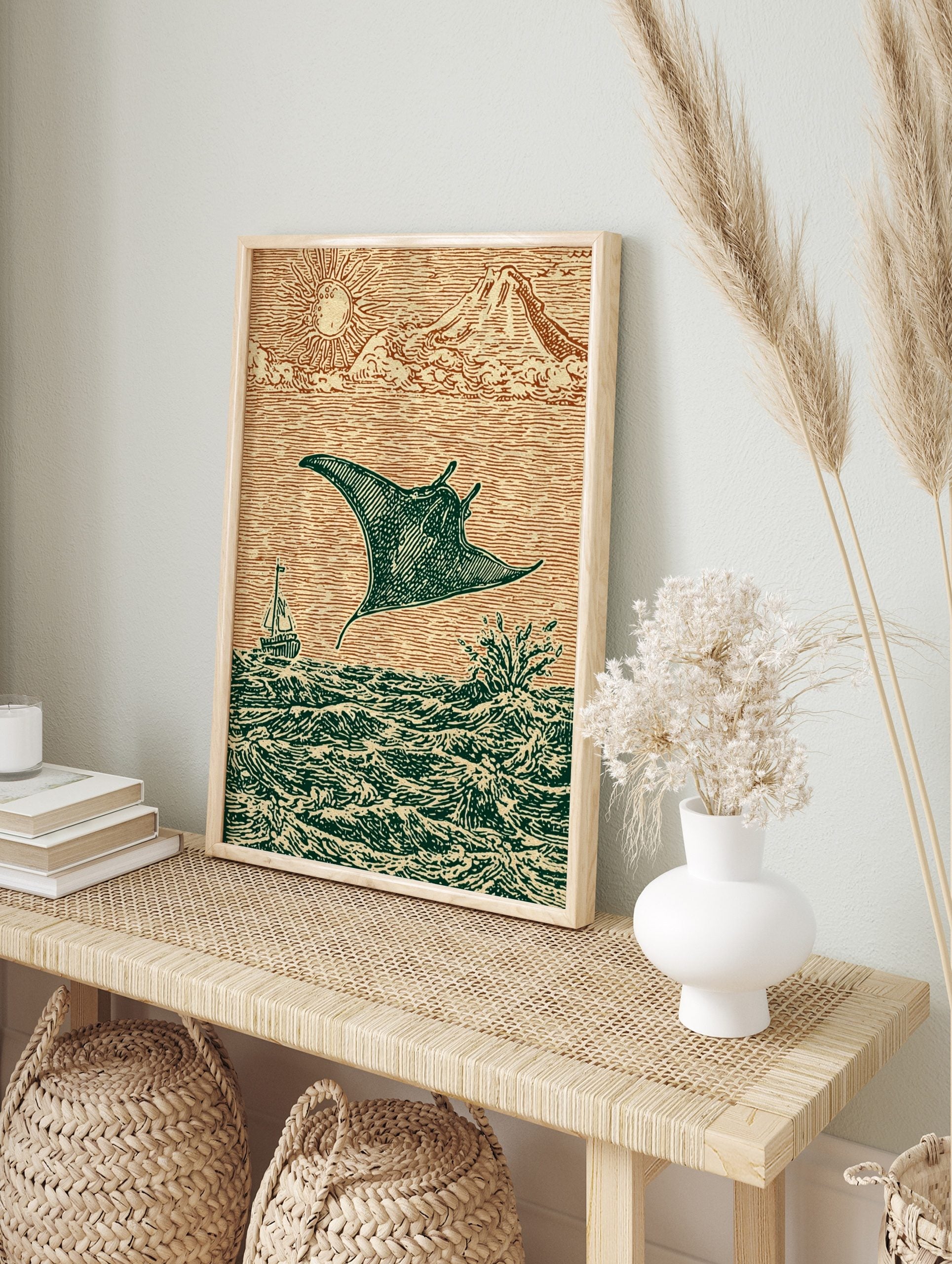 Woodcut style print of a manta ray leaping from ocean waves with a sailboat, sun, and, in an alternate framed mockup